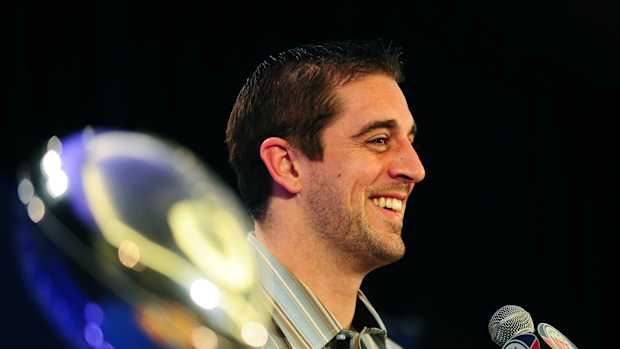 Aaron Rodgers next to the Lombardi Trophy